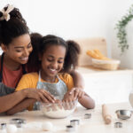 Loving black mother and daughter cooking together