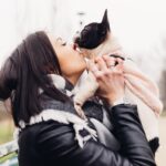 Young beautiful woman kissing her french bulldog